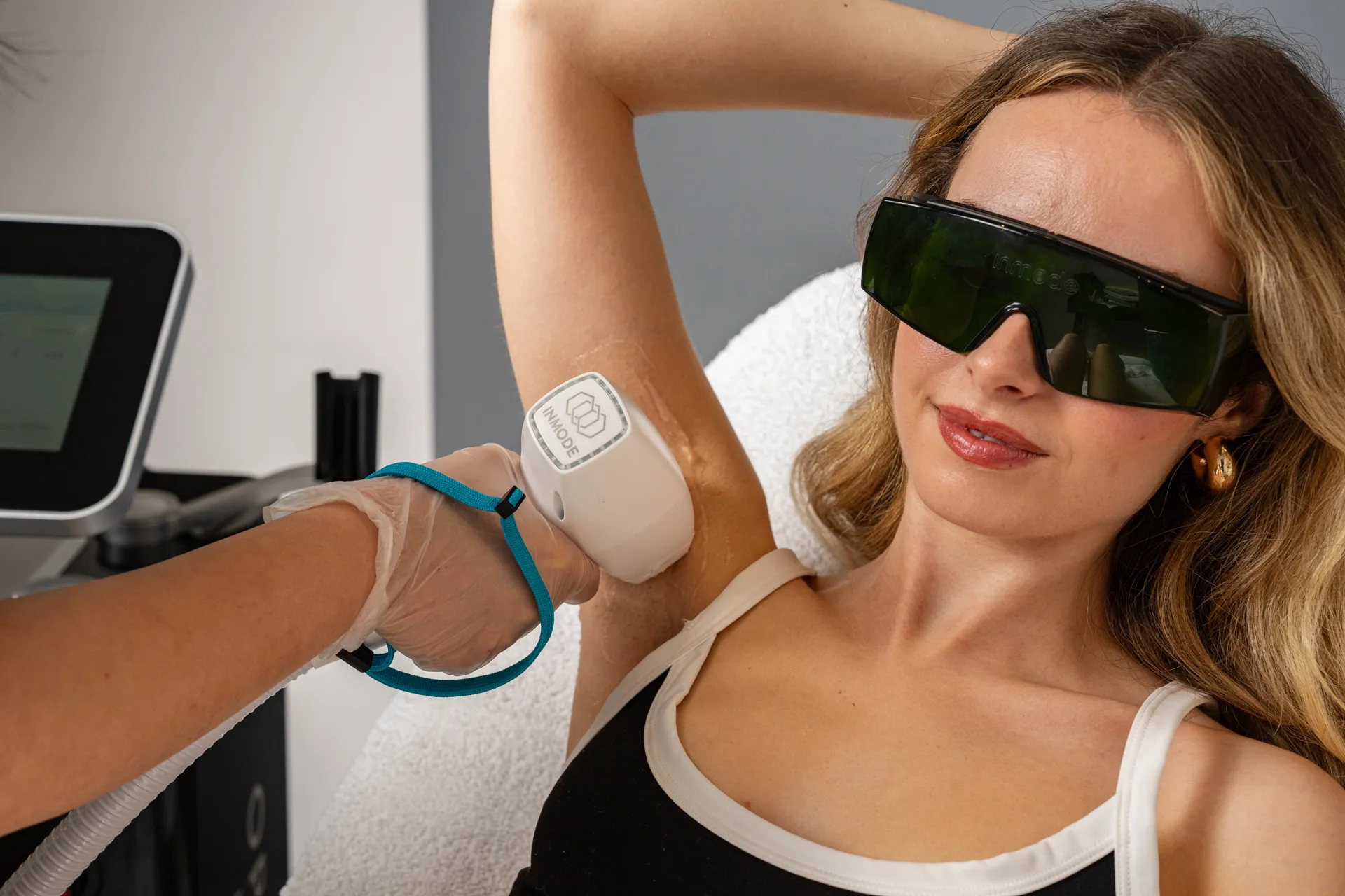 Woman receiving laser hair removal treatment on underarm at The Axis Clinic London using InMode technology.