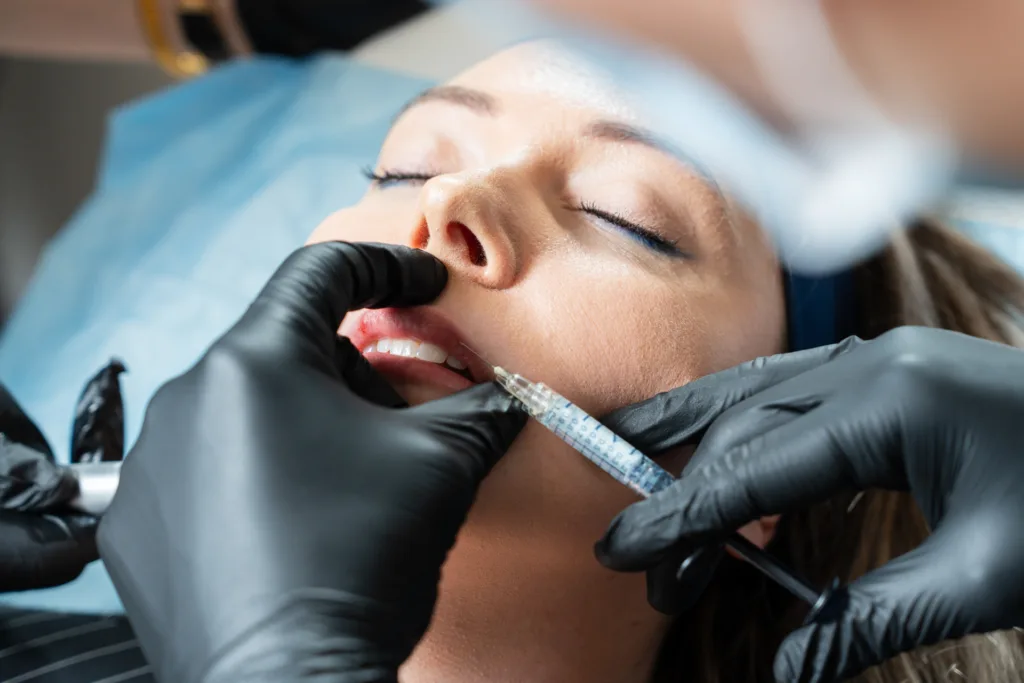 Woman receiving lip filler injection performed by qualified practitioner at The Axis Clinic London